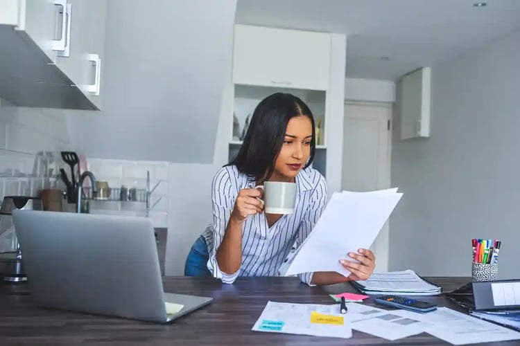 A woman reviewing her finances to see if she is able to refinance a car loan.