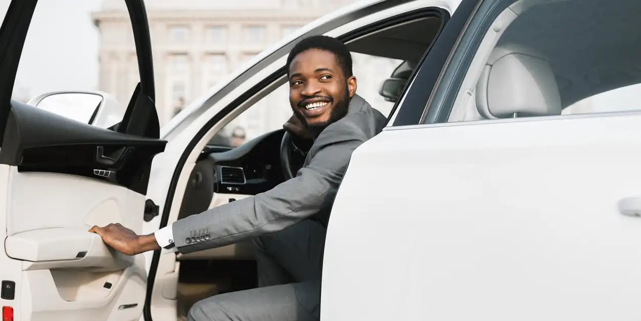 A man who just purchased a new vehicle is driving it through the city. 