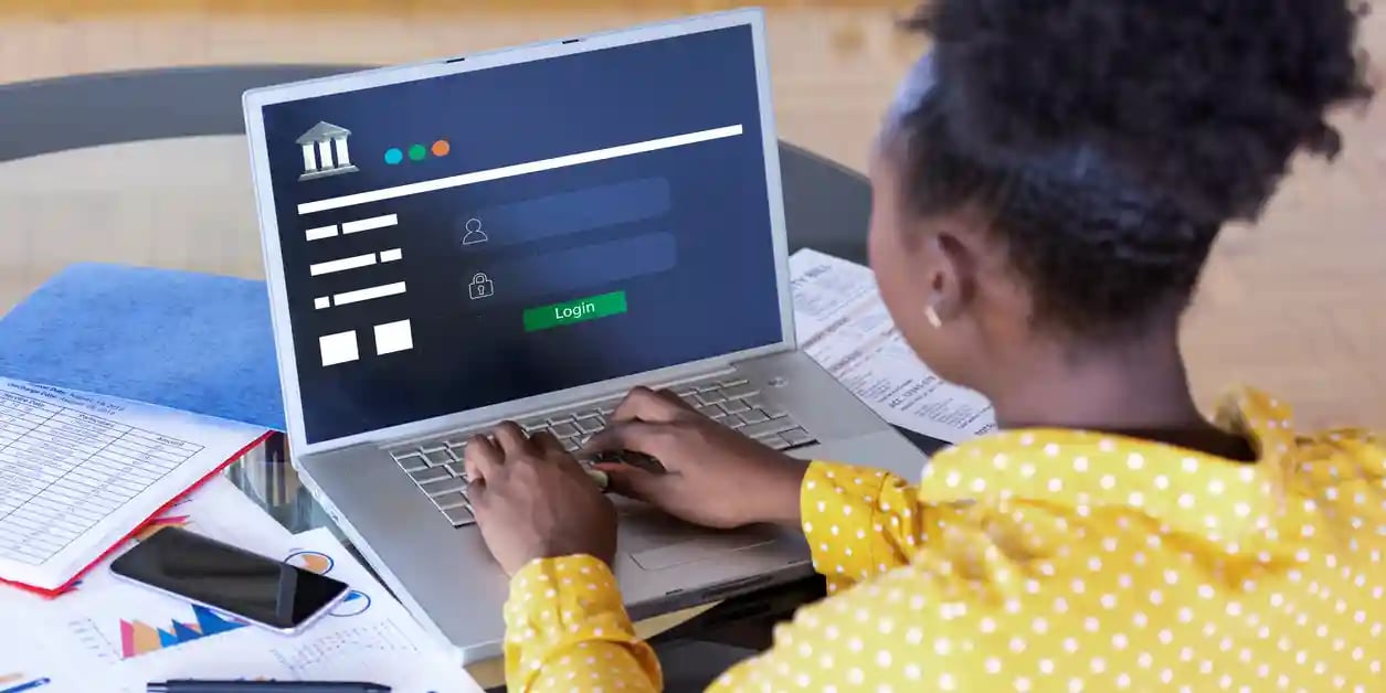 Rearview of a woman using her laptop for online banking.