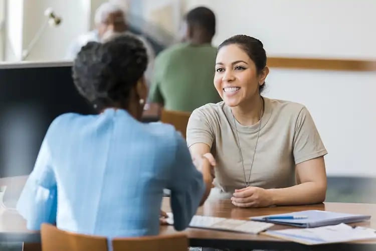 A woman chooses to use a physical bank instead of online baking for credit options.